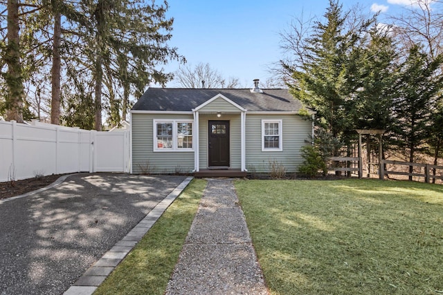 bungalow featuring fence, roof with shingles, a front yard, driveway, and a gate