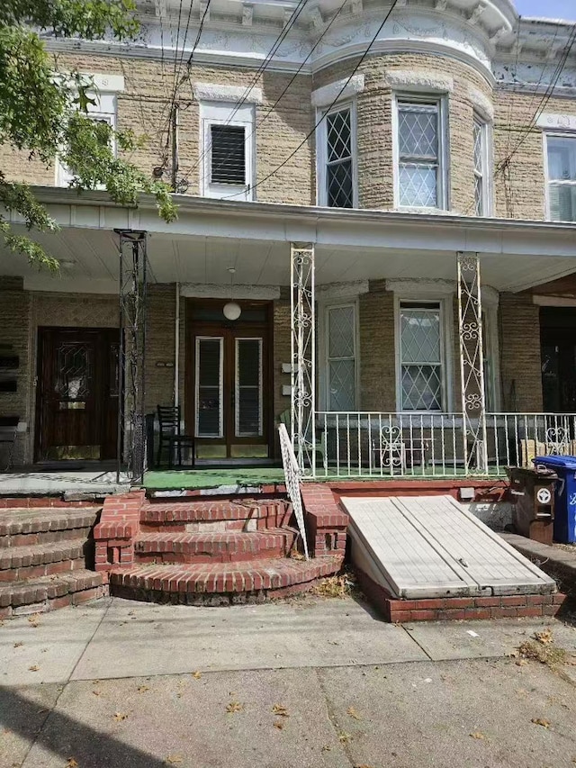 property entrance with brick siding and covered porch