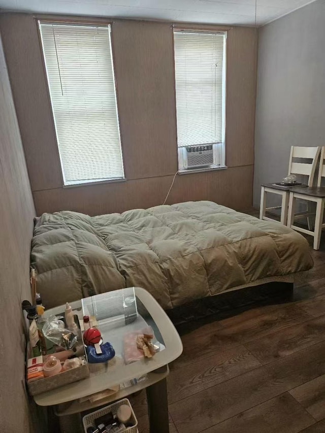 bedroom featuring multiple windows, cooling unit, and wood finished floors