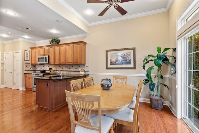 dining space with visible vents, baseboards, light wood-style flooring, and ornamental molding