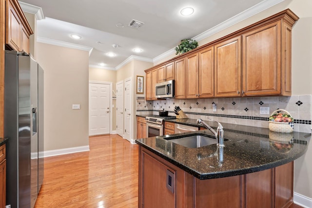 kitchen featuring brown cabinetry, visible vents, appliances with stainless steel finishes, and a sink