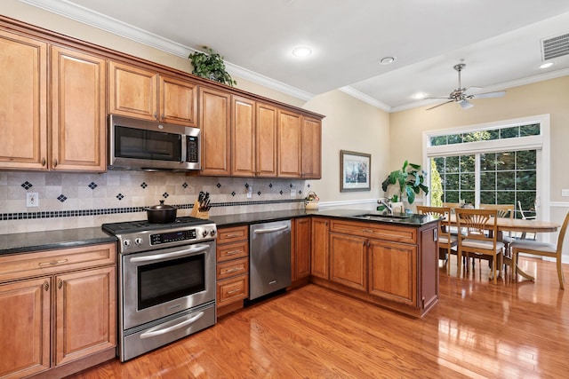 kitchen featuring visible vents, stainless steel appliances, brown cabinetry, crown molding, and decorative backsplash