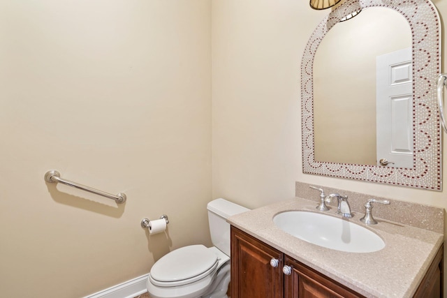 half bathroom featuring baseboards, toilet, and vanity