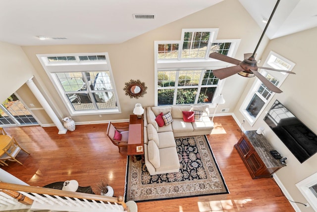 living room with visible vents, a ceiling fan, baseboards, and wood finished floors