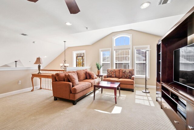 living area with light colored carpet, vaulted ceiling, baseboards, and visible vents