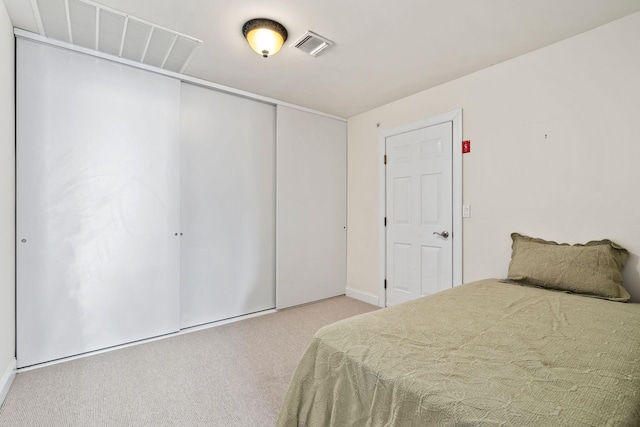 carpeted bedroom featuring visible vents and a closet