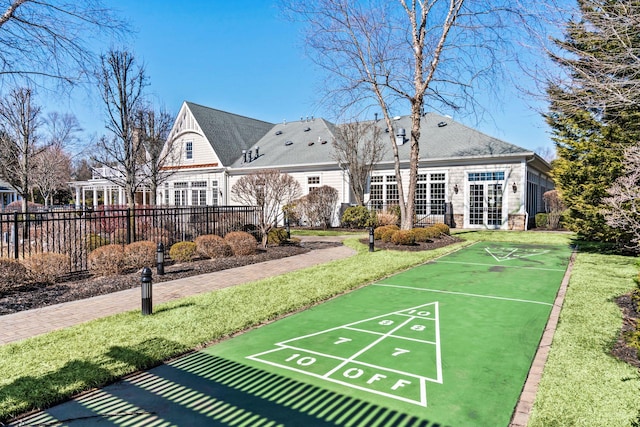 view of community with shuffleboard and fence