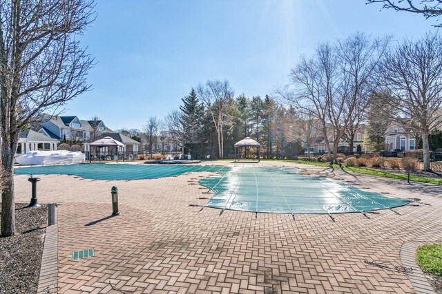 community pool with a gazebo and a patio area