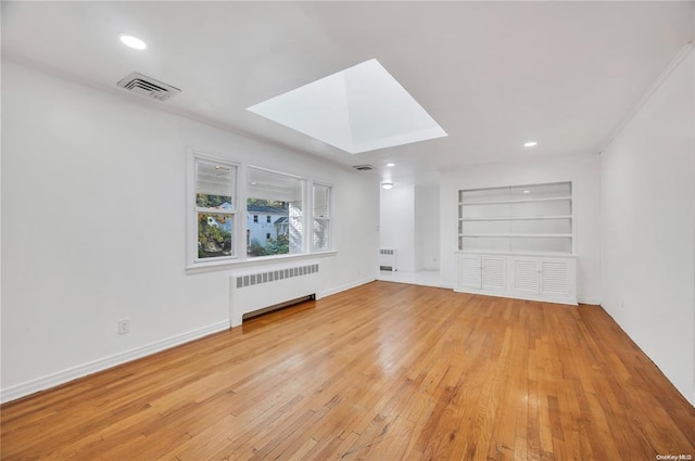 21 Ravine Rd, Great Neck, NY 11023 - spare room with built in features, visible vents, light wood-type flooring, and radiator heating unit