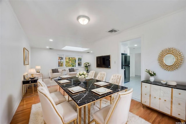 21 Ravine Rd, Great Neck, NY 11023 - dining area with visible vents, light wood-style flooring, recessed lighting, a skylight, and crown molding