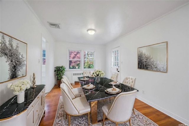 21 Ravine Rd, Great Neck, NY 11023 - dining space featuring wood finished floors, visible vents, baseboards, radiator heating unit, and ornamental molding