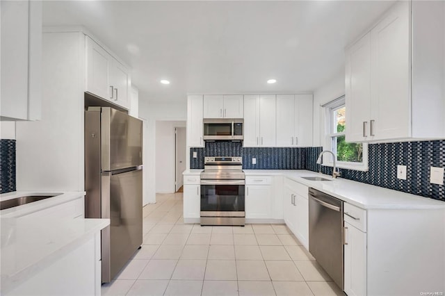 21 Ravine Rd, Great Neck, NY 11023 - kitchen featuring tasteful backsplash, white cabinets, appliances with stainless steel finishes, and a sink