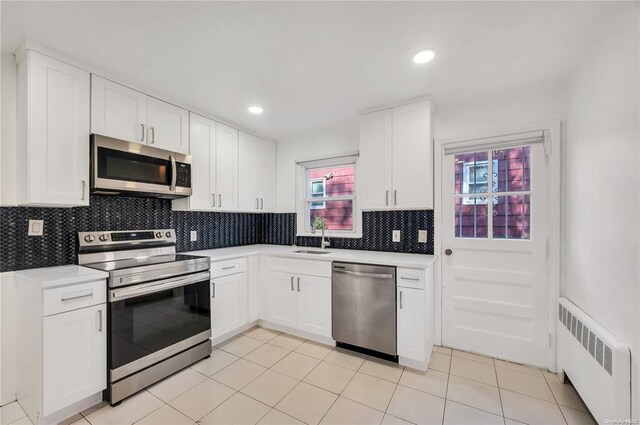 21 Ravine Rd, Great Neck, NY 11023 - kitchen featuring light countertops, radiator, appliances with stainless steel finishes, and a sink