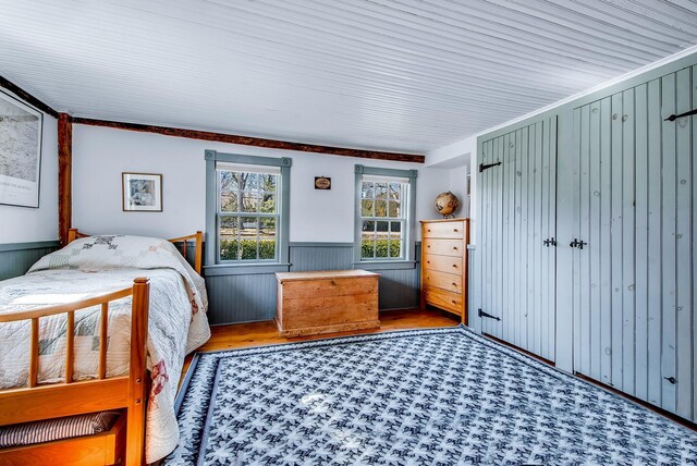 unfurnished bedroom featuring a wainscoted wall and wood finished floors