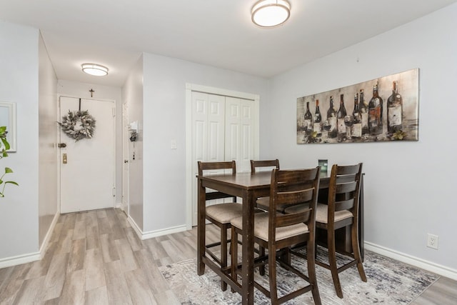 dining room featuring baseboards and light wood finished floors