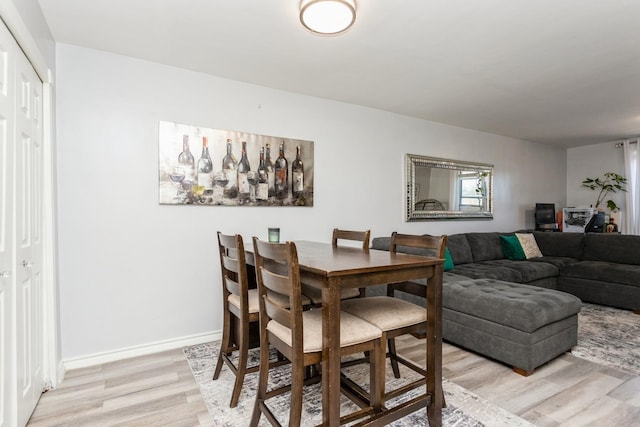 dining room featuring light wood finished floors and baseboards