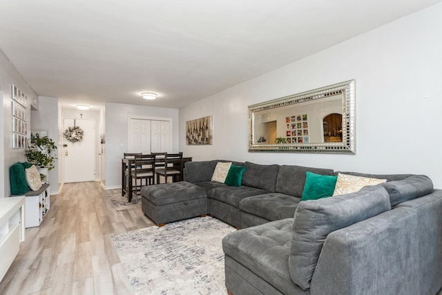 living room with baseboards and light wood-style flooring