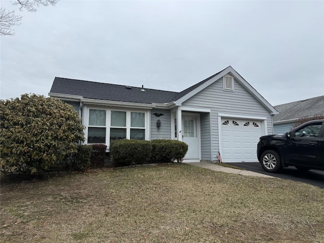 ranch-style home featuring a front lawn, an attached garage, and a shingled roof