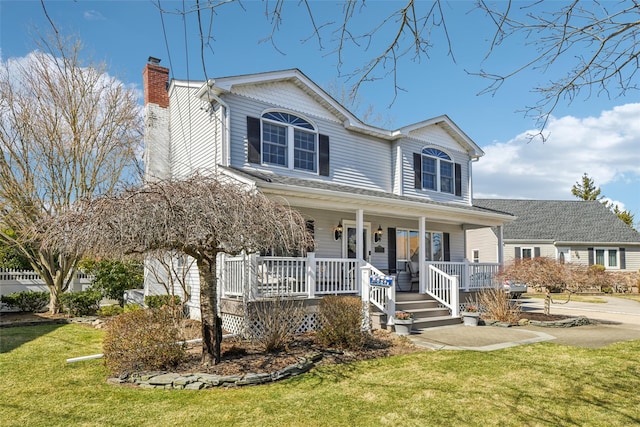 traditional-style home featuring a porch, a front lawn, and a chimney