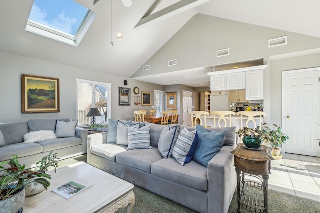 living area with visible vents, a skylight, and ceiling fan