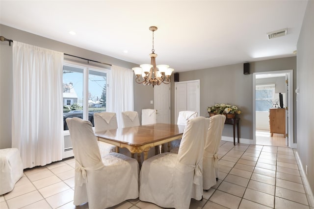 dining space featuring light tile patterned flooring, baseboards, visible vents, and a chandelier