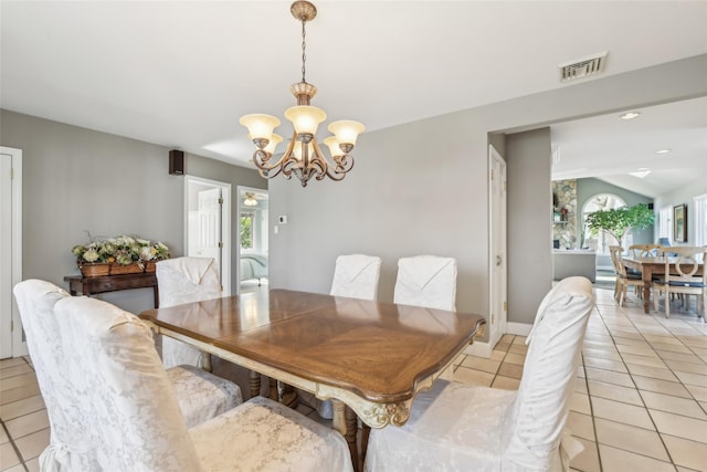 dining room with visible vents, baseboards, a chandelier, vaulted ceiling, and light tile patterned floors