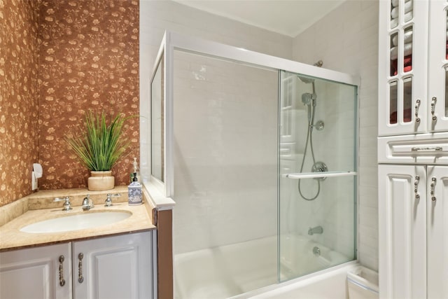 full bath featuring wallpapered walls, combined bath / shower with glass door, and a sink