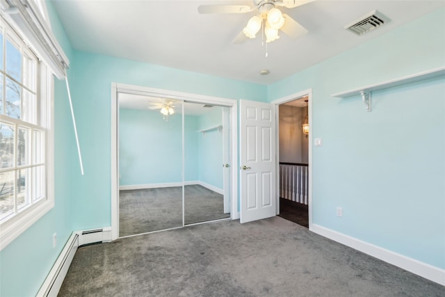 unfurnished bedroom with visible vents, a baseboard heating unit, a closet, carpet floors, and baseboards