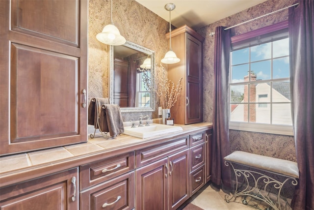 bathroom with wallpapered walls and vanity