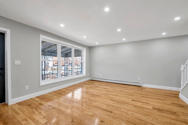 spare room with recessed lighting, light wood-style floors, and a baseboard radiator