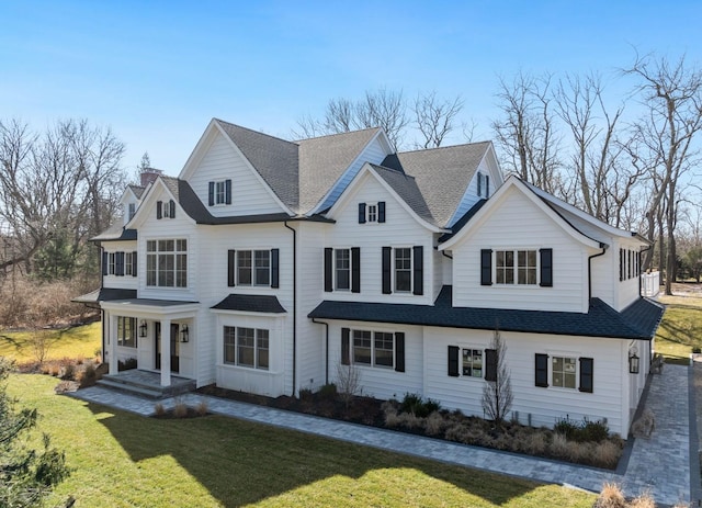 view of front of property featuring a shingled roof and a front yard