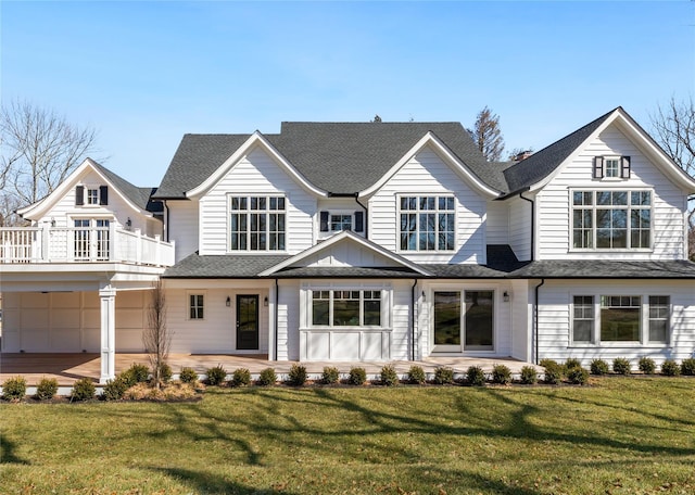 view of front facade featuring a front lawn, concrete driveway, a garage, and a shingled roof