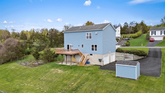 back of house with a storage unit, a garage, a deck, stairway, and driveway