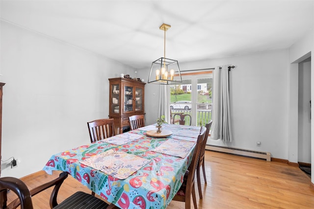 dining space with baseboards, a baseboard heating unit, light wood-style flooring, and a chandelier