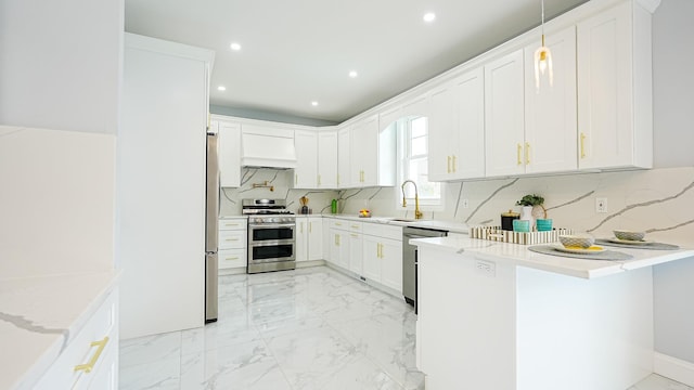 kitchen with marble finish floor, white cabinetry, appliances with stainless steel finishes, a peninsula, and custom exhaust hood