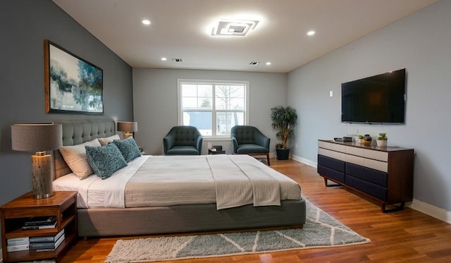 bedroom with recessed lighting, baseboards, and wood finished floors