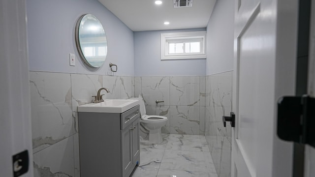 bathroom with visible vents, toilet, marble finish floor, wainscoting, and vanity