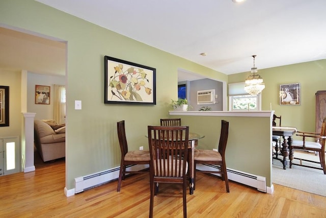 dining room with an inviting chandelier, light wood-style floors, and baseboard heating