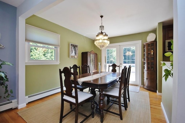 dining area featuring baseboards, a baseboard radiator, french doors, a notable chandelier, and light wood-type flooring