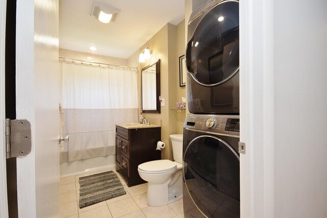 full bath featuring tile patterned floors, stacked washer and dryer, toilet, shower / bath combo, and vanity