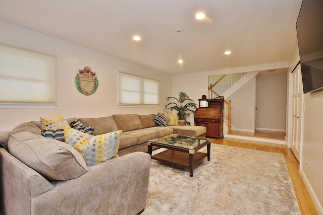 living room featuring recessed lighting, light wood-type flooring, baseboards, and stairway