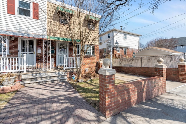 view of front of home with covered porch and brick siding