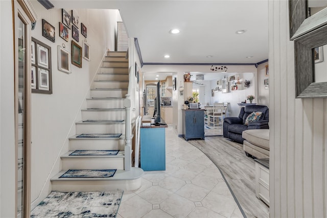 stairway with wood finished floors, recessed lighting, and crown molding