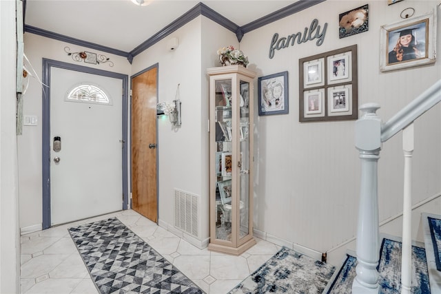 tiled foyer entrance featuring baseboards, visible vents, stairway, and ornamental molding