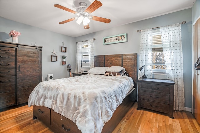 bedroom featuring multiple windows, light wood-type flooring, cooling unit, and ceiling fan