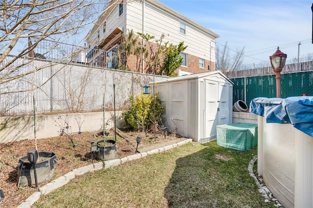 view of yard featuring an outdoor structure, a fenced backyard, and a storage shed