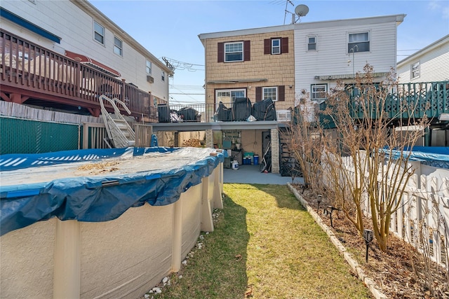 exterior space with stairs, a wooden deck, and a covered pool