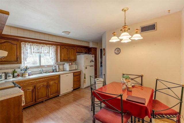 101 Grissom Way, Hauppauge, NY 11788 - kitchen featuring visible vents, a sink, light countertops, white appliances, and brown cabinetry