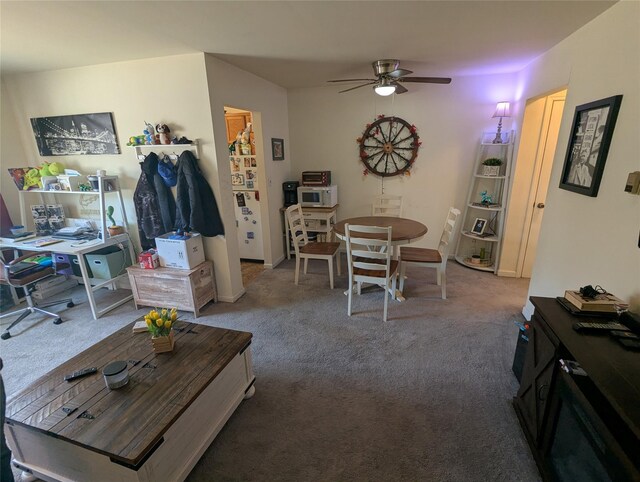 carpeted living room with baseboards and a ceiling fan