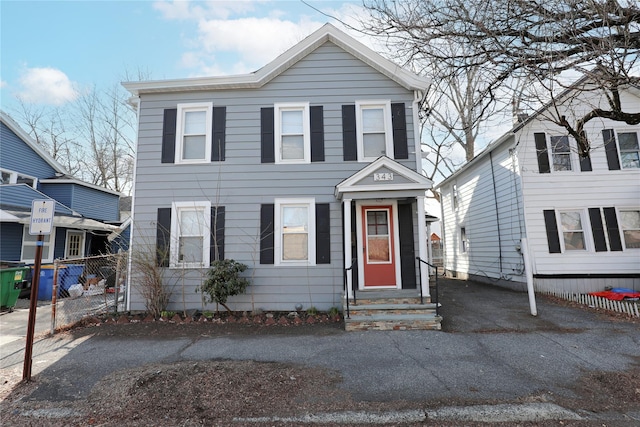 view of front of house with fence, driveway, and entry steps